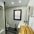 Chic bathroom with a bathtub, dark ceiling, and minimalist decor.