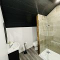 Bright bathroom with a shower, and white fixtures.